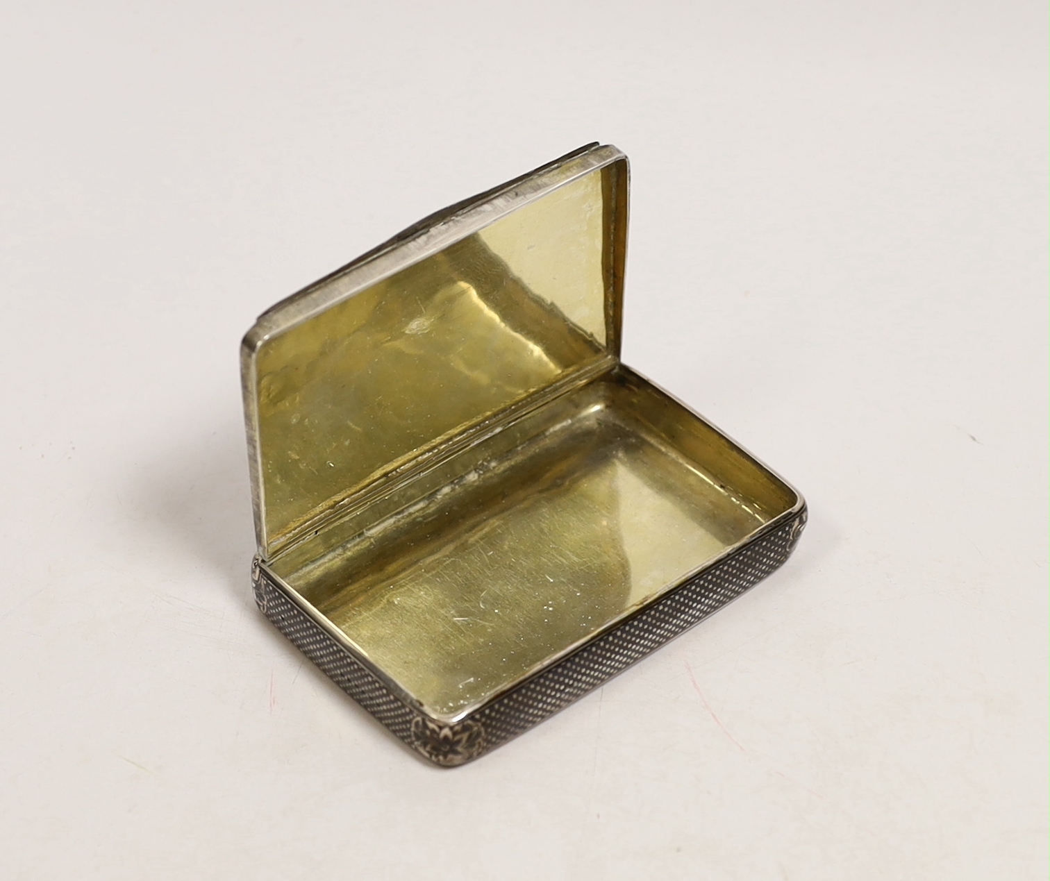 A 19th century Russian? white metal and niello rectangular snuff box, decorated with a pensive figure in a landscape with script, unmarked, 97mm, 119 grams.